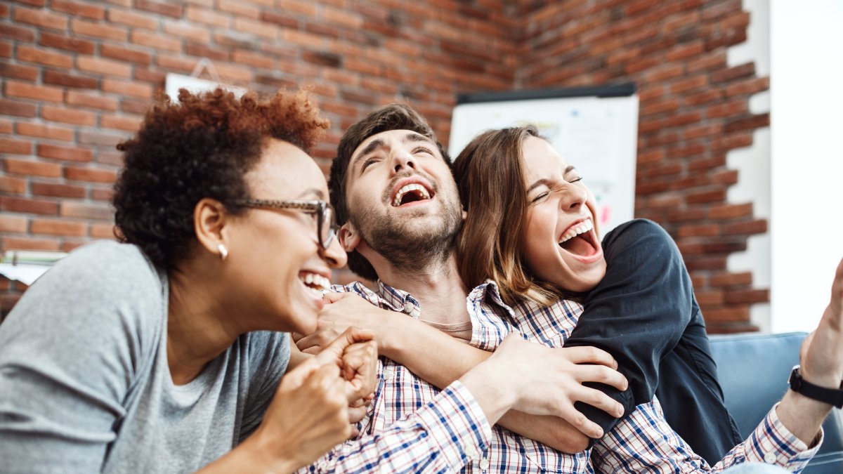 Colleagues rejoicing their work, shouting, embracing at business meeting.