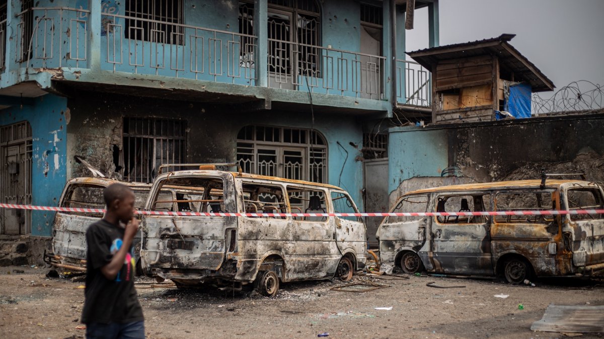 Un niño pasa junto a los restos de vehículos quemados tras los enfrentamientos en Goma el 30 de enero de 2025.