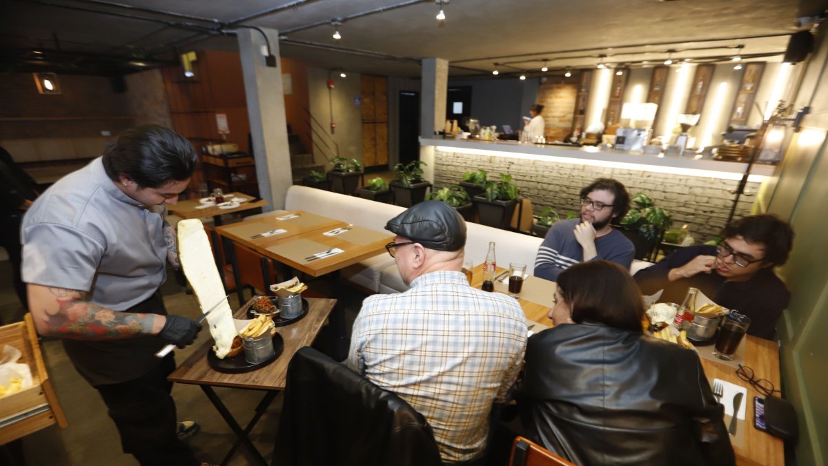 Expectativa. El momento de colocar el queso fundido sobre las hamburguesas es el más esperado por los comensales.