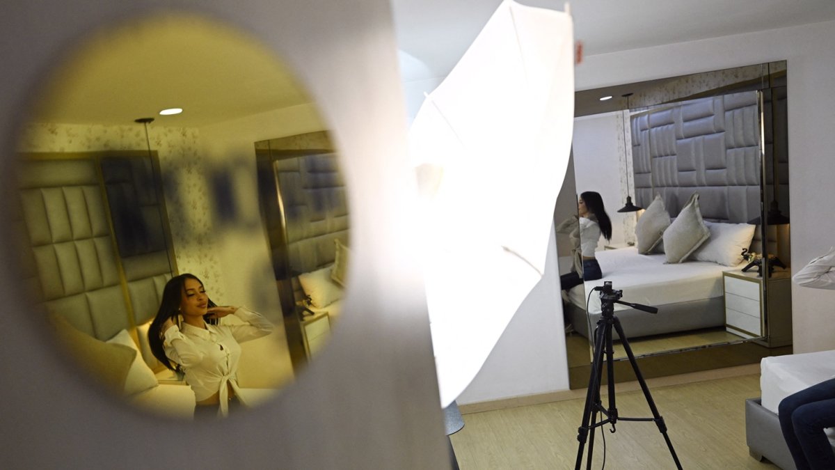 La modelo de Gold Line Studios, Alison Quintero, se arregla el cabello en una habitación de las instalaciones de Gold Line Studios en Bogotá el 19 de diciembre de 2024.