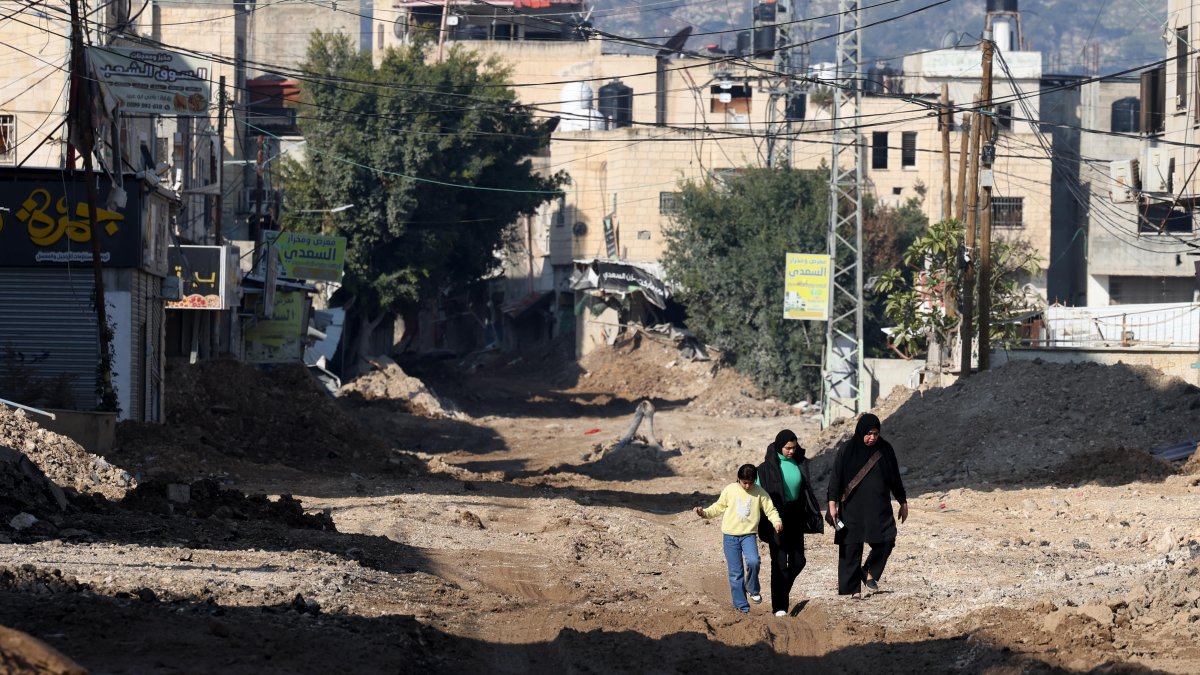 La gente camina por una calle llena de escombros tras una operación militar israelí en la ciudad cisjordana de Jenin.