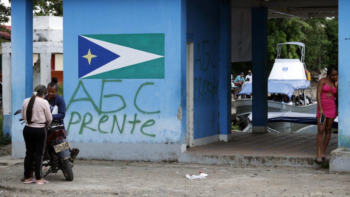 Urguía (Colombia). Una mujer aparece cerca de grafitis de las Autodefensas Gaitanistas de Colombia (AGC).