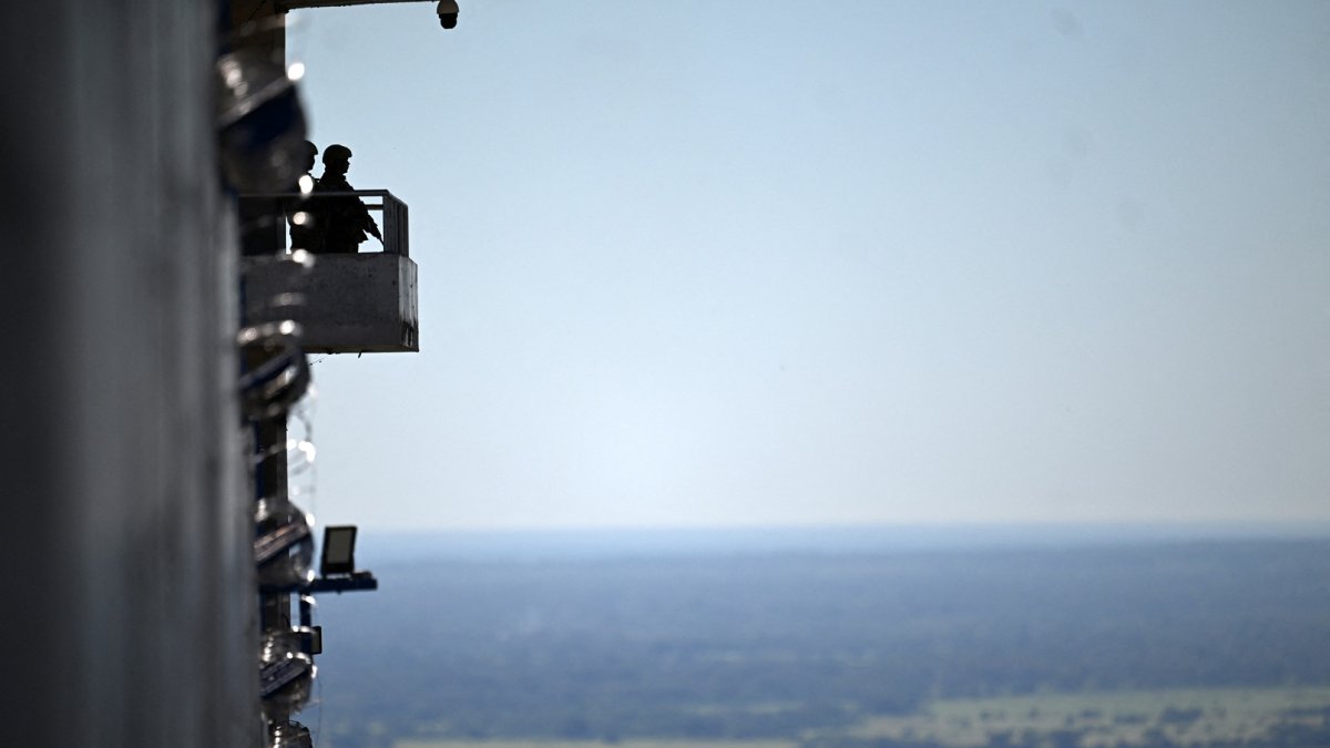 Un soldado hace guardia desde una torre dentro de la mega prisión del Centro de Internamiento Antiterrorista (CECOT), donde se encuentran recluidos cientos de miembros de las pandillas MS-13 y..