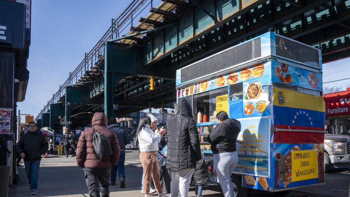 Personas consumen alimentos en un puesto de comida callejera este miércoles, en Queens Nueva York (Estados Unidos).