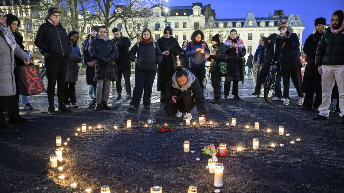 Ciudadanos se reúnen alrededor de flores y velas para honrar a las víctimas del tiroteo en la escuela de Orebro, en Malmo, Suecia.