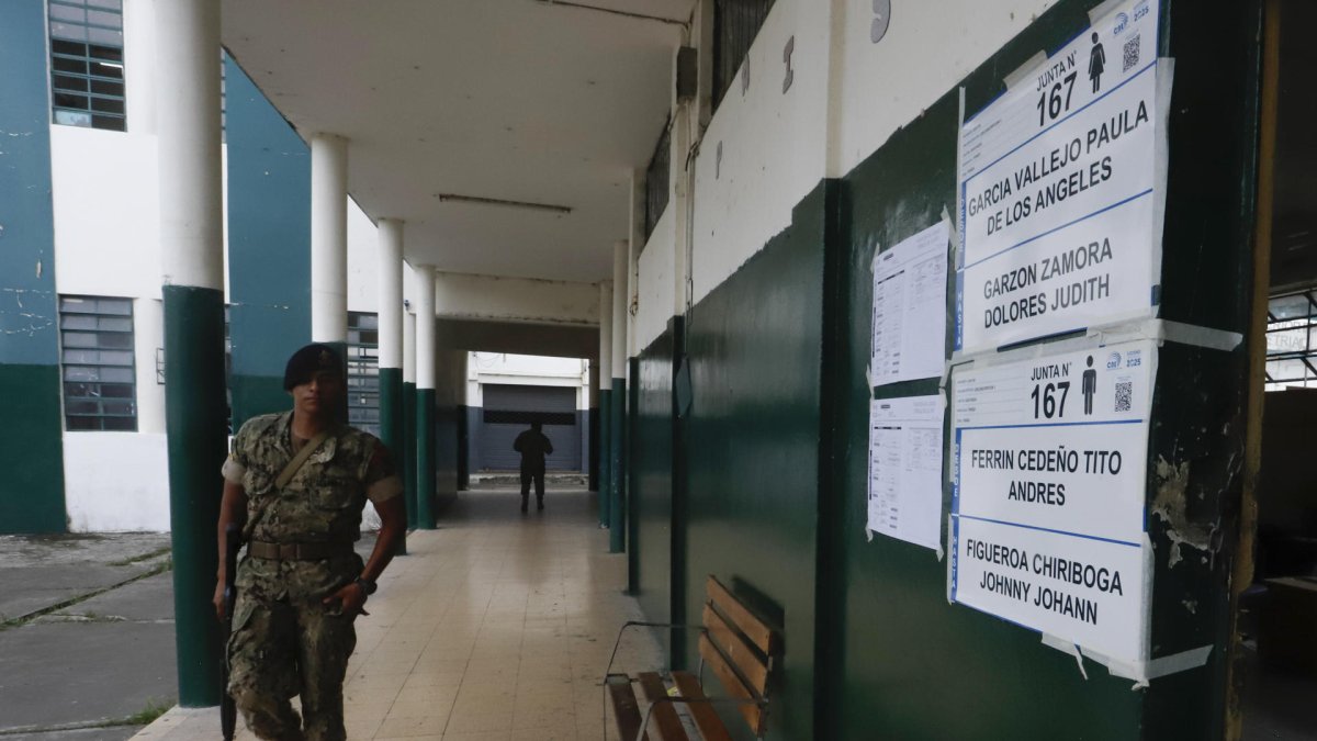 Un integrante del ejército ecuatoriano patrulla al cierre de la jornada electoral este domingo, en un centro de votación en Guayaquil (Ecuador).