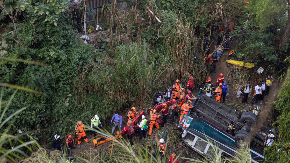 Integrantes de organismos de socorro trabajan en la zona donde ocurrió el accidente de un autobús, que cayó en un río de aguas residuales este 10 de febrero de 2025 al norte de la Ciudad de Guatemala.