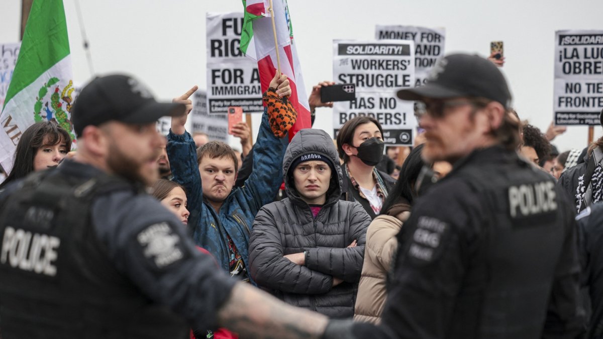 Manifestantes observan a los agentes de la policía después de que los agentes realizaron uno de los dos arrestos durante una marcha contra el ICE en Seattle, el 8 de febrero de 2025.
