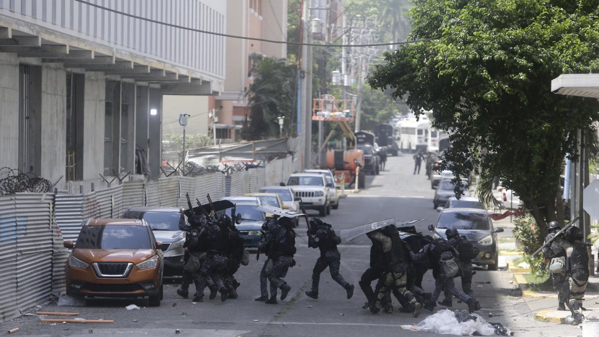 Policías antidisturbios enfrentan a integrantes de grupos sindicales durante protestas este miércoles en la cinta costera en Ciudad de Panamá (Panamá).
