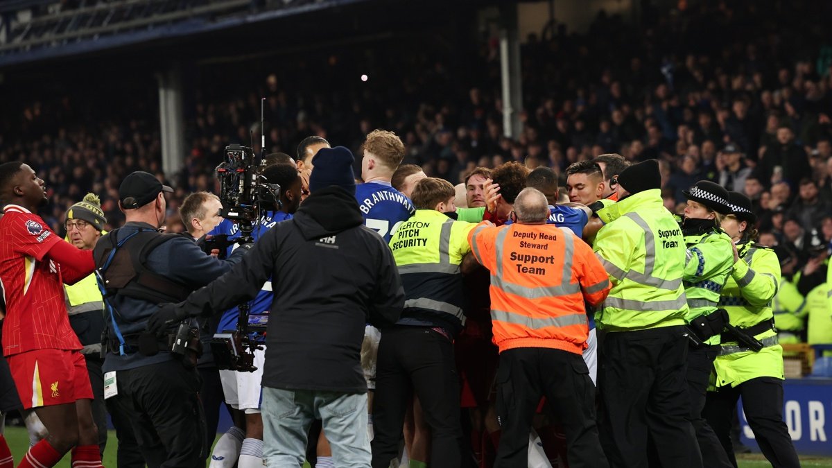 La policía tiene que intervenir para separar a jugadores de ambos equipos durante el partido de la Premier League que han jugado Everton FC y Liverpool FC.