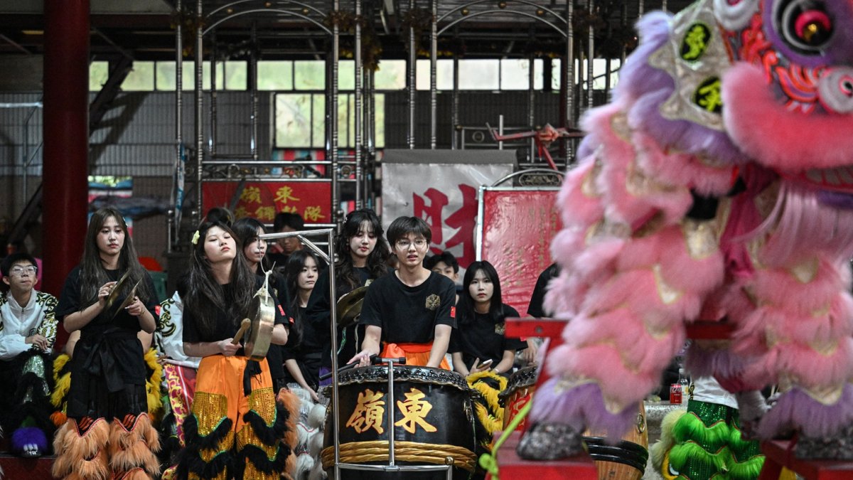 Miembros de una compañía de danza del león tocando tambores y percusiones durante una sesión de práctica de danza del león en un templo ancestral en Shantou, en la provincia de Guangdong.