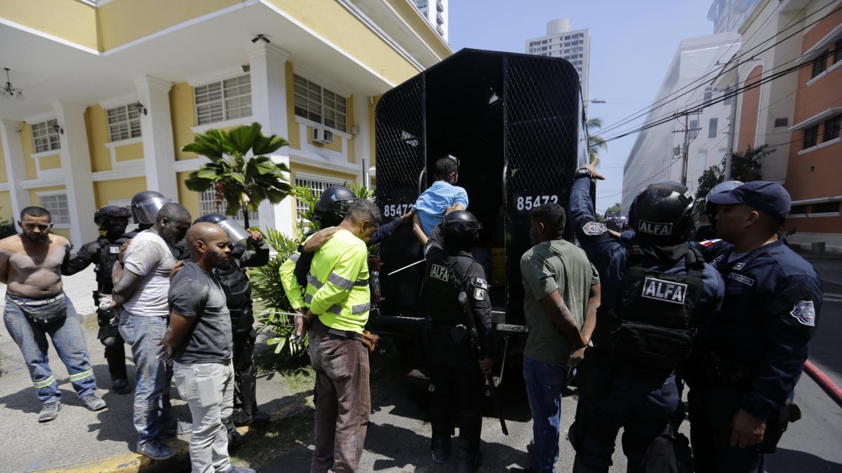 Policías antidisturbios custodian a integrantes de grupos sindicales durante protestas este miércoles en Ciudad de Panamá (Panamá).