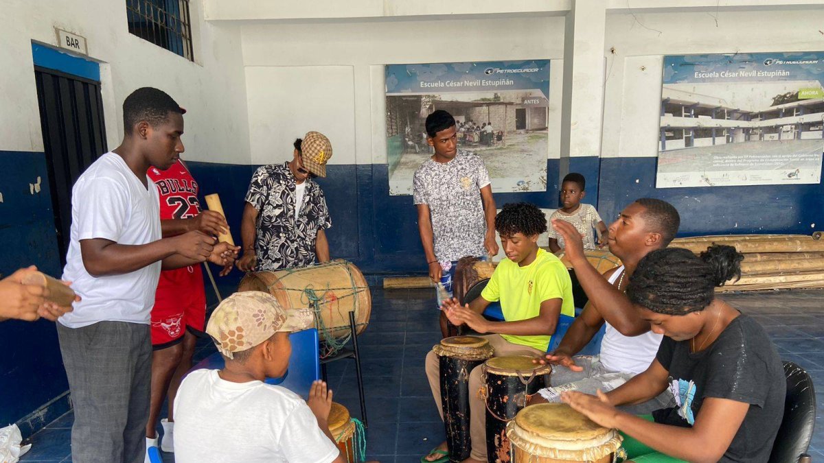 Mientras los niños tocan, el sonido del bombo se une a la melodía resonando con la fuerza de un corazón que late al compás de la vida.