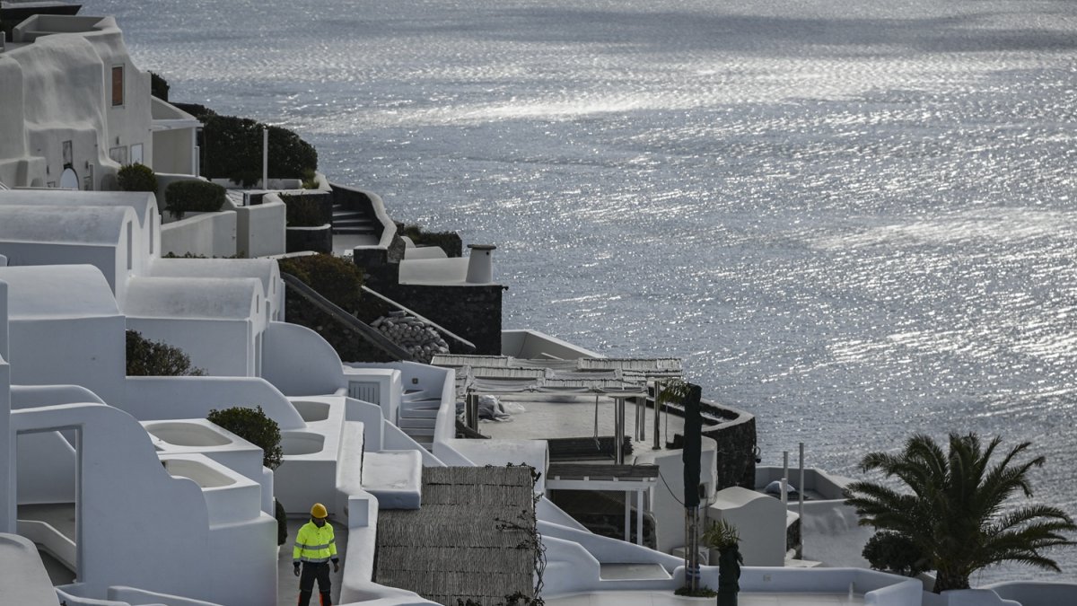 Un empleado municipal camina en el pueblo de Oia en la isla griega de Santorini mientras las autoridades restringieron el acceso a los turistas.