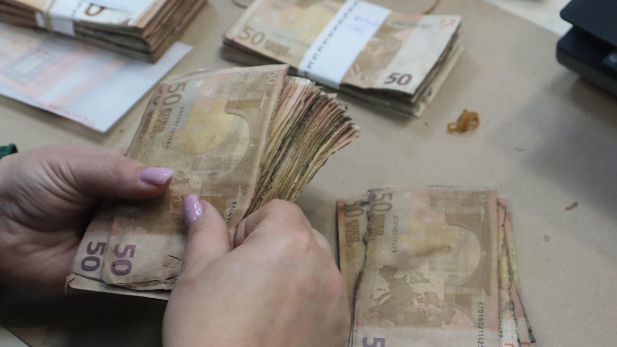 Una trabajadora del Área de Operaciones con Efectivo Banco de Portugal maneja un fajo de billetes de 50 euros estropeados por la humedad.