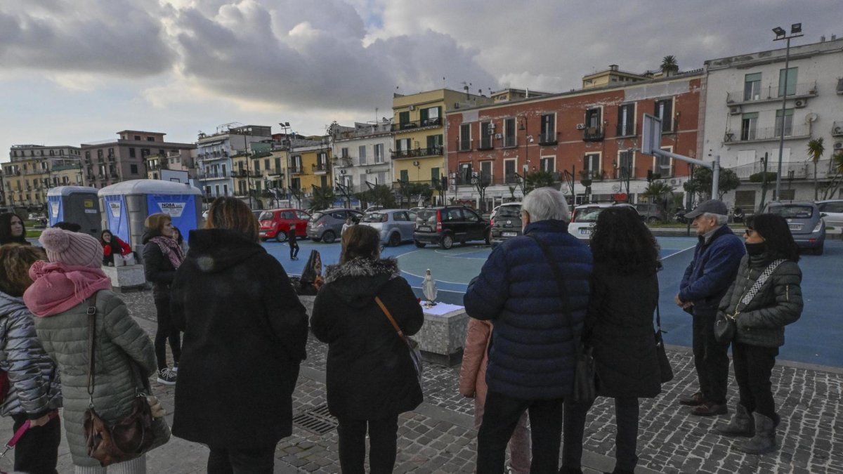 Fieles rezan el rosario frente a una estatua de la Virgen en la cancha de baloncesto del paseo marítimo de Pertini en Pozzuoli, cerca de Nápoles (Italia), el 17 de febrero de 2025.