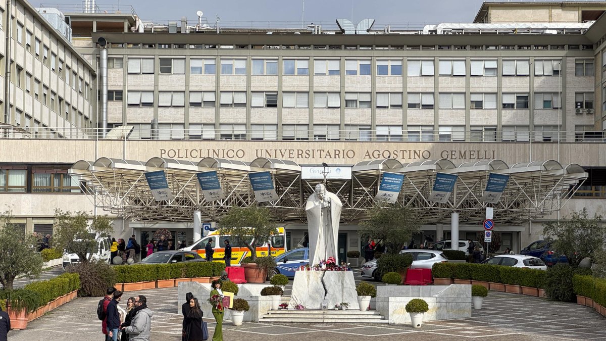 Velas y flores a los pies de la escultura de Juan Pablo II a las puertas del Hospital Gemelli de Roma donde permanece ingresado el papa Francisco, este miércoles.