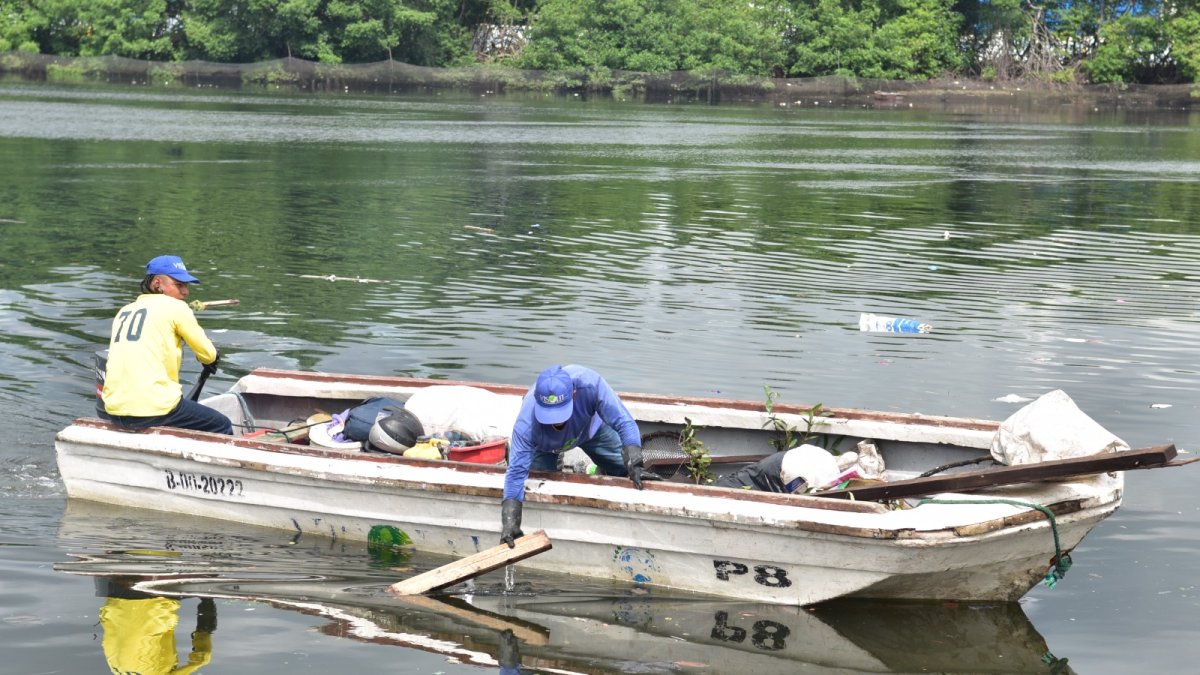 Los trabajadores municipales realizan su recorrido en balsas.