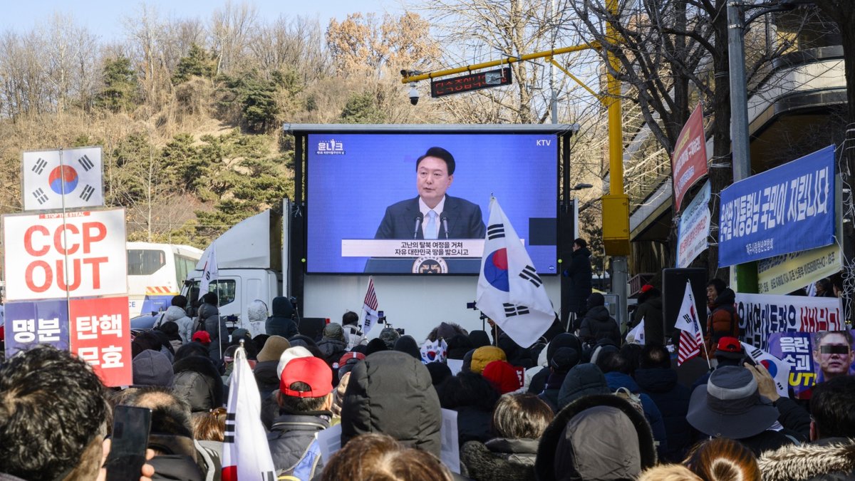 Los partidarios miran imágenes de archivo de los discursos del líder surcoreano Yoon Suk Yeol (C) en una pantalla cerca del Tribunal del Distrito Central en Seúl el 20 de febrero de 2025.