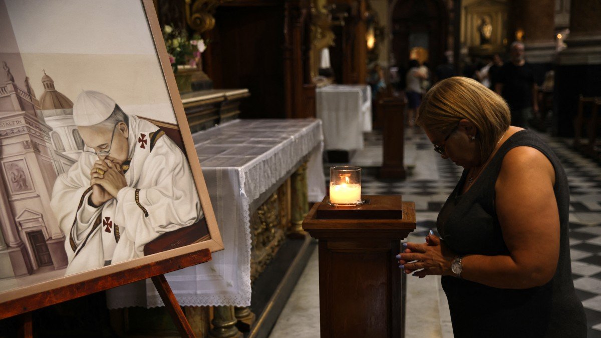 Una mujer reza junto a un cuadro que representa al Papa Francisco en la Basílica de San José de Flores en Buenos Aires, este domingo 23 de febrero de 2025.