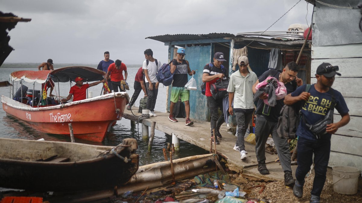 Migrantes venezolanos y colombianos llegan a la isla Gardi Sugdub este domingo, en la comarca Guna Yala, en Puerto de Cartí (Panamá).