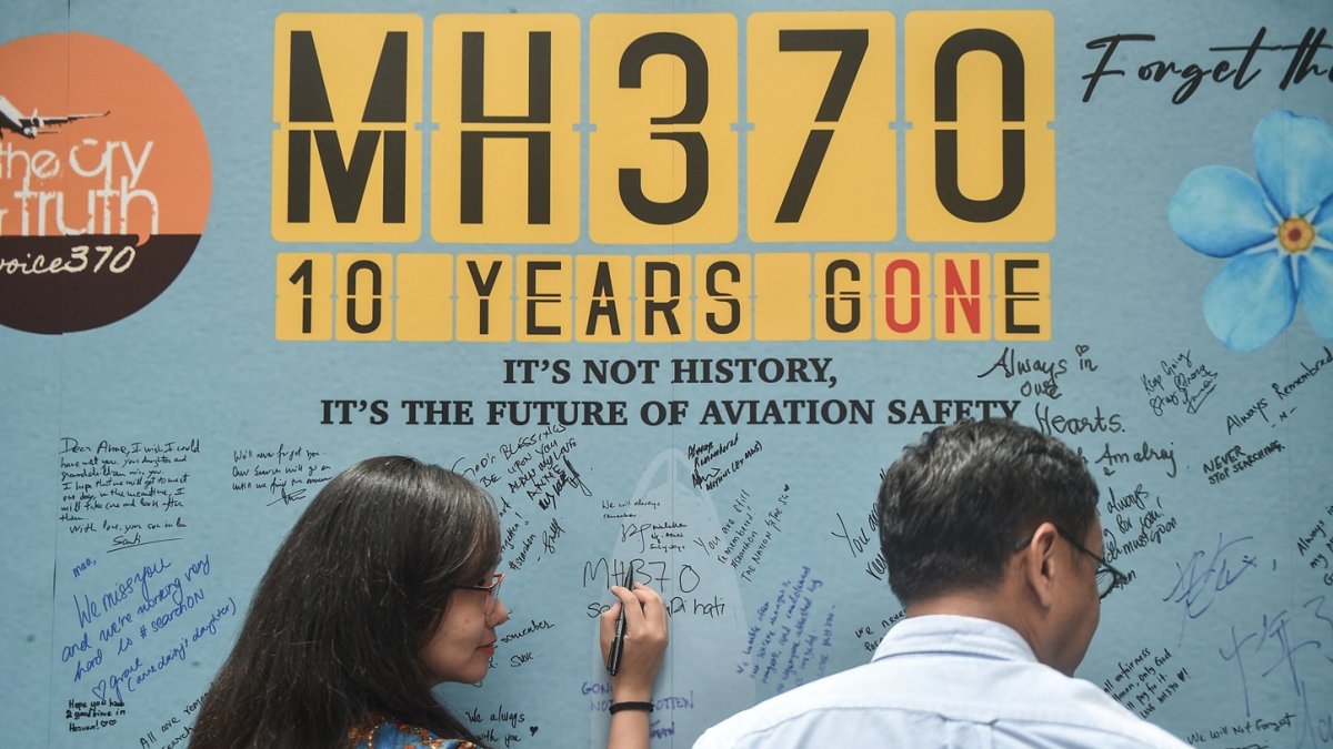 Una mujer escribe un mensaje durante un evento organizado por familiares de los pasajeros y simpatizantes para conmemorar el décimo año desde que el vuelo MH370 de Malaysia Airlines.