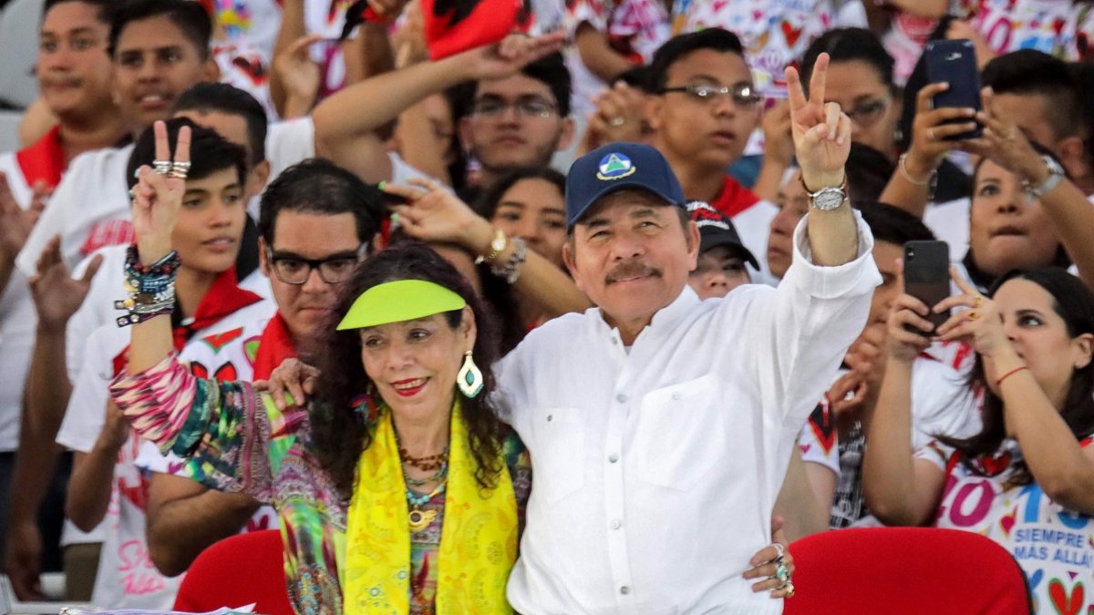 El presidente Daniel Ortega y su esposa, Rosario Murillo, hacen el signo V durante la conmemoración de aniversario de la Revolución Sandinista en la plaza La Fe en Managua.