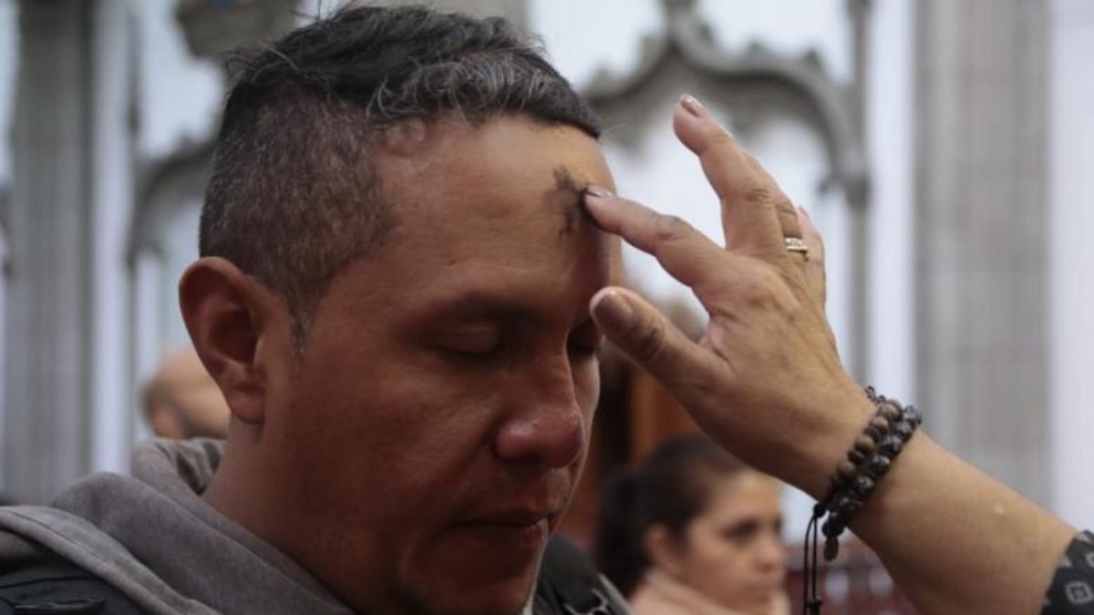 Un creyente católico recibe en la frente la cruz de ceniza durante una misa.