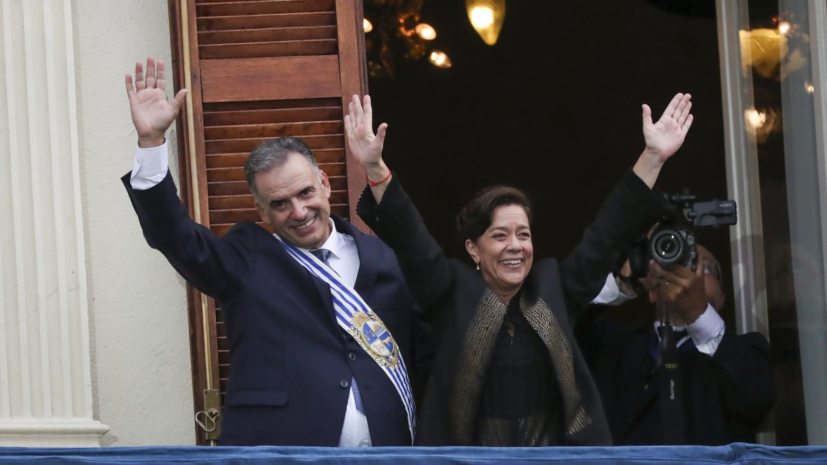 El presidente de Uruguay, Yamandú Orsi (i), saluda acompañado por la primera dama, Laura Alonso.