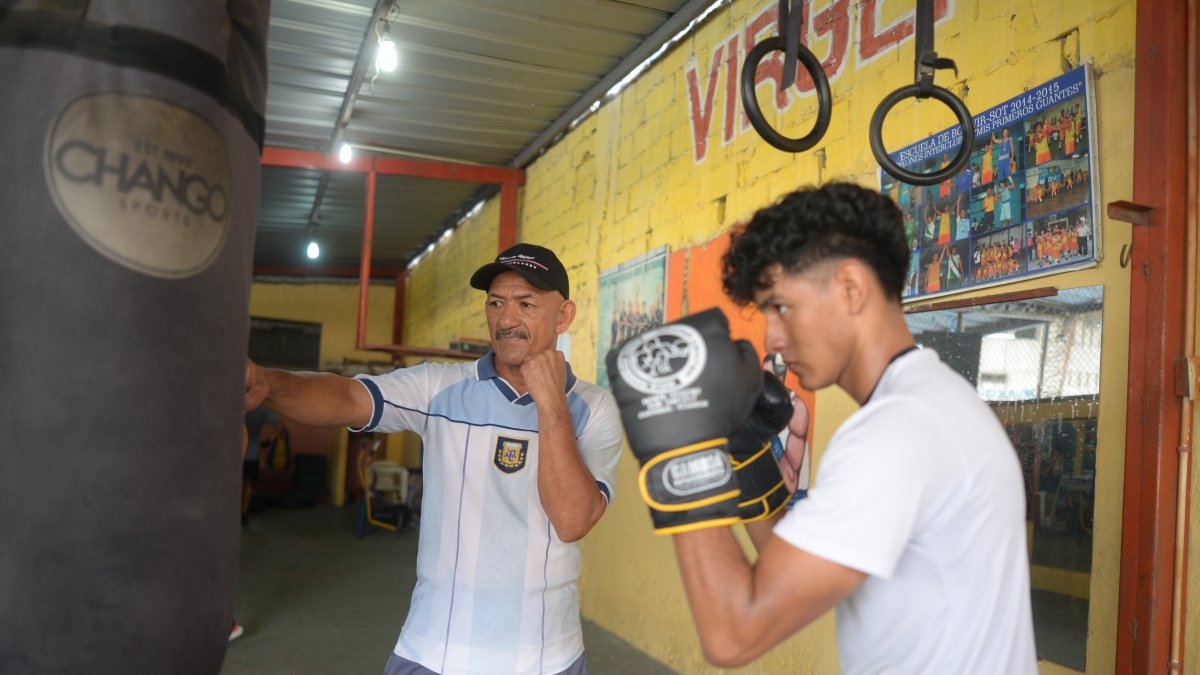 El entrenador y excampeón de boxeo Pablo Álvarez (c), comparte sus enseñanzas todas las tardes con jóvenes en el suburbio de Guayaquil.