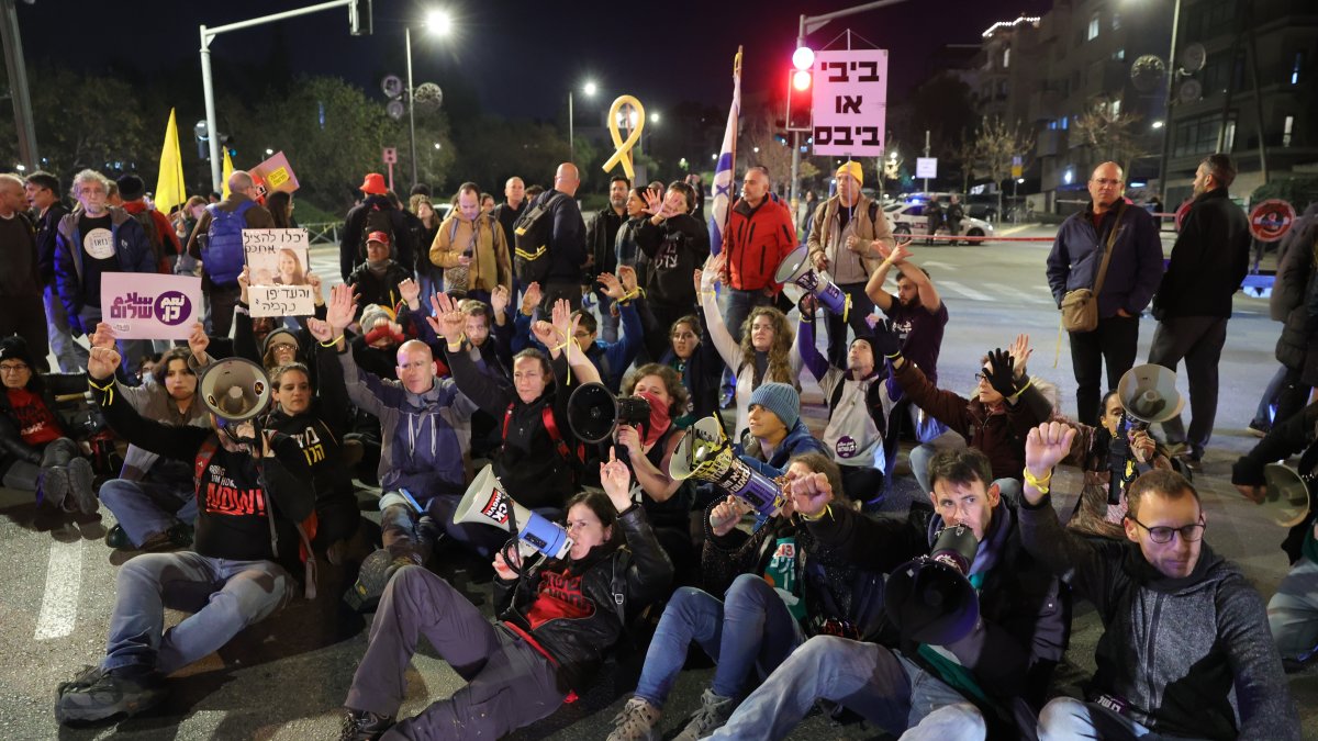 Las familias de los rehenes israelíes retenidos por Hamás en Gaza, junto con sus partidarios, bloquean una carretera durante una protesta.