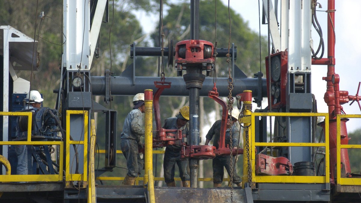 Cuatro personas realizan trabajo en uno de los pozos de petróleo de Ecuador, como en el campo Sacha.