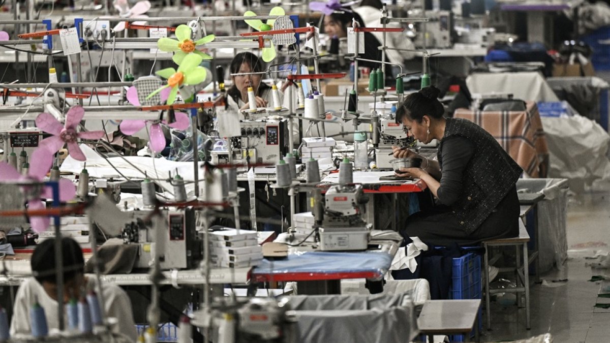 Un empleado de un taller de costura de ropa comiendo durante una pausa para la cena en Guangzhou, provincia de Guangdong, en el sur de China.