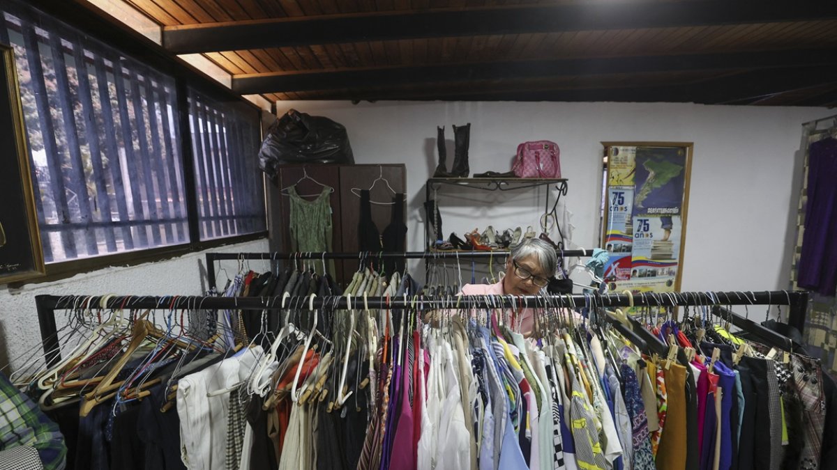 Una maestra mira ropa dentro de una tienda de segunda mano administrada por la Federación Venezolana de Maestros (FVM) en Caracas, el 17 de febrero de 2025.