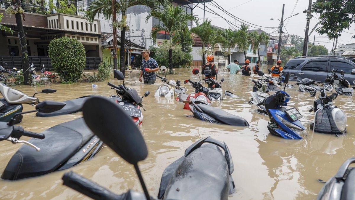 Los rescatistas caminan a través de las aguas de la inundación cerca de motocicletas sumergidas en una zona residencial de Bekasi, Java Occidental, Indonesia, el 4 de marzo de 2025.