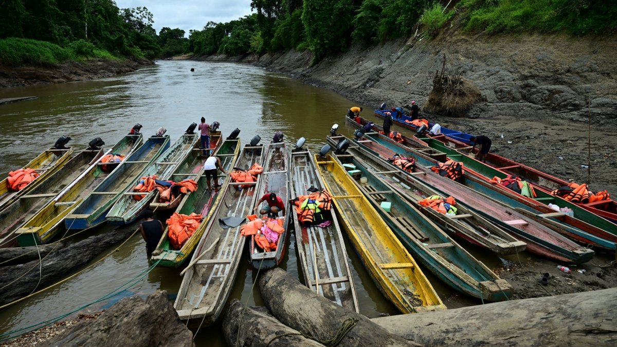 Migrantes venezolanos limpian embarcaciones en el Centro de Recepción Temporal de Migrantes en Lajas Blancas, en la selvática provincia de Darién, 250 km al este de la Ciudad de Panamá.