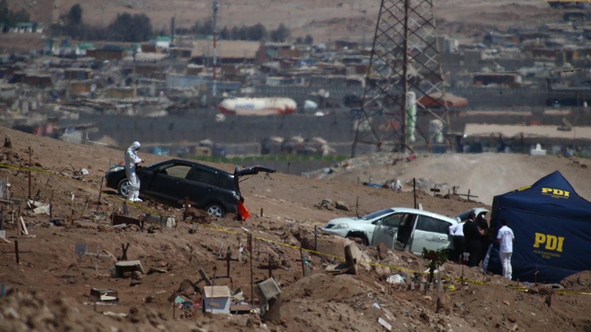 Santiago. Policías examinan un vehículo con tres personas ajusticiadas.