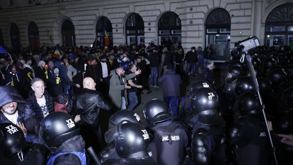 Partidarios del ultranacionalista Calin Georgescu discuten con policías antidisturbios durante una protesta anoche que se volvió violenta frente a la Oficina Electoral Central.