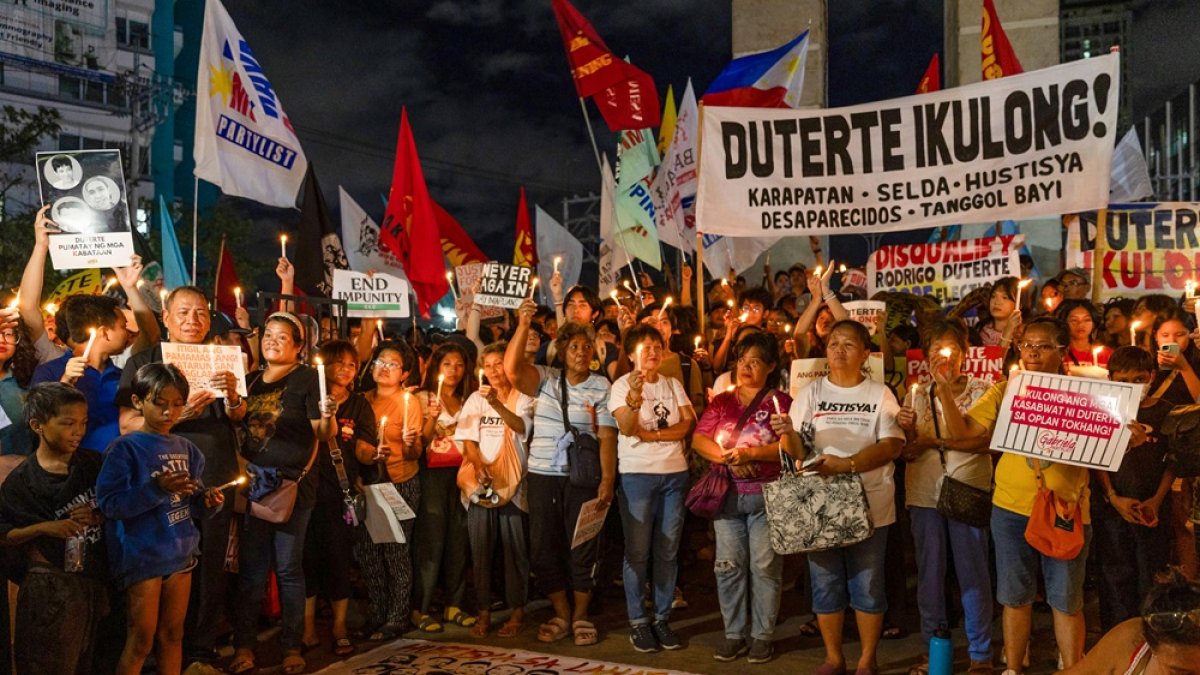 Manifestantes durante vigilia con velas para exigir justicia para las víctimas de la guerra contra las drogas, tras arresto del expresidente Rodrigo Duterte, en la ciudad de Quezón.