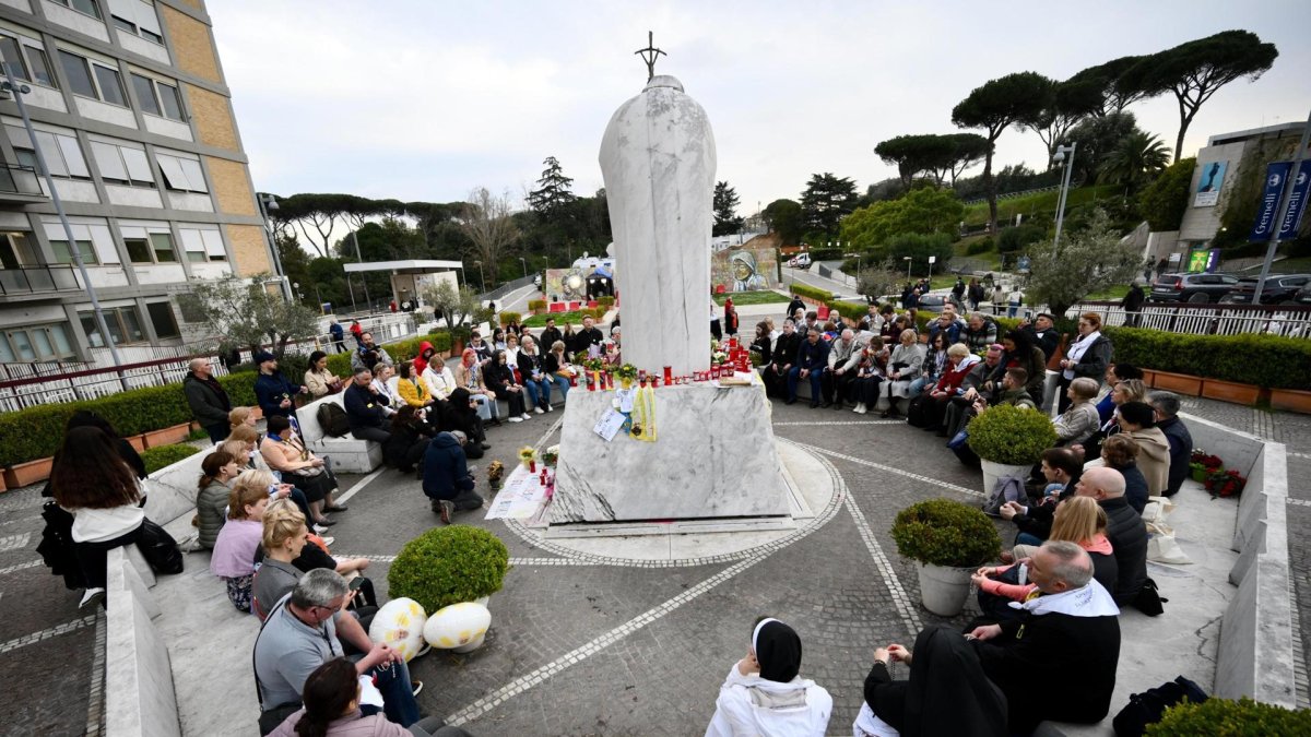 Un grupo de peregrinos rusos se reúne junto a la estatua de Juan Pablo II en la entrada del Hospital Gemelli, donde está hospitalizado el Papa Francisco, en Roma, Italia, el 11 de marzo de 2025.