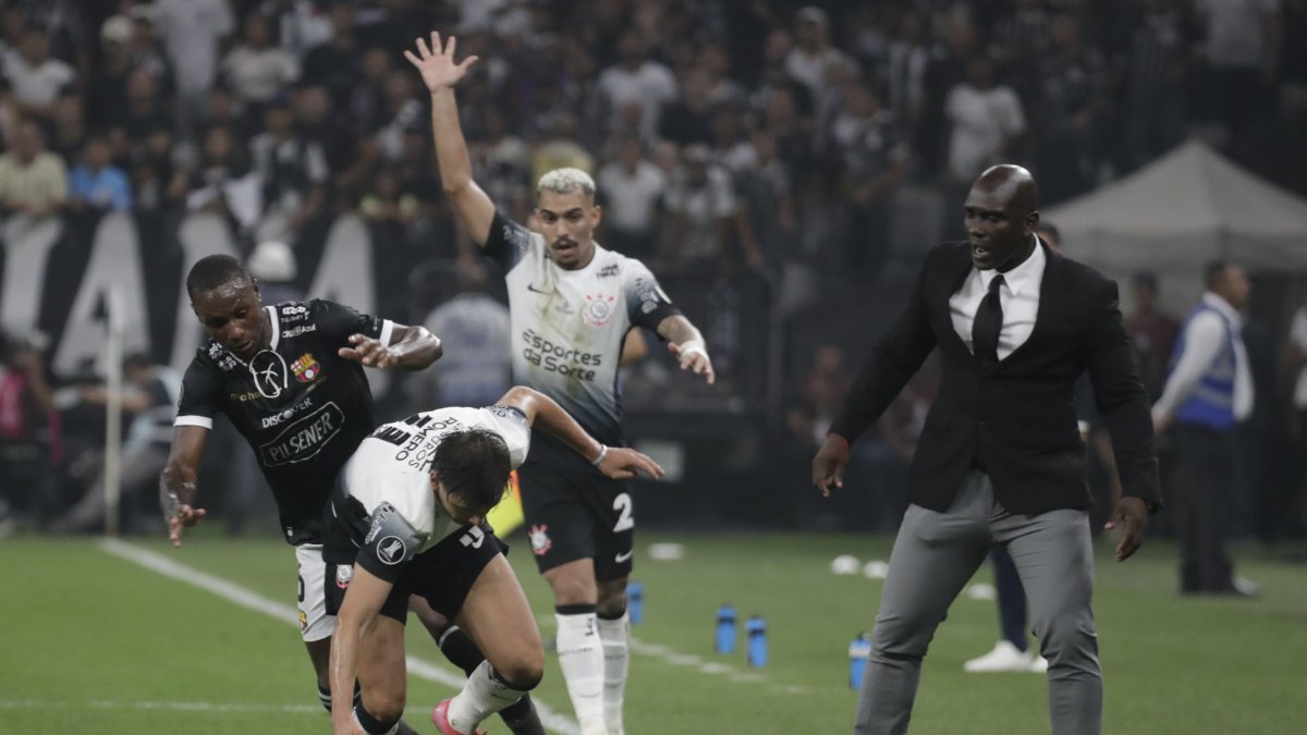 Ángel Romero (c) de Corinthians disputa el balón con Aníbal Chalá (i) de Barcelona en un partido de la tercera ronda de la Copa Libertadores.