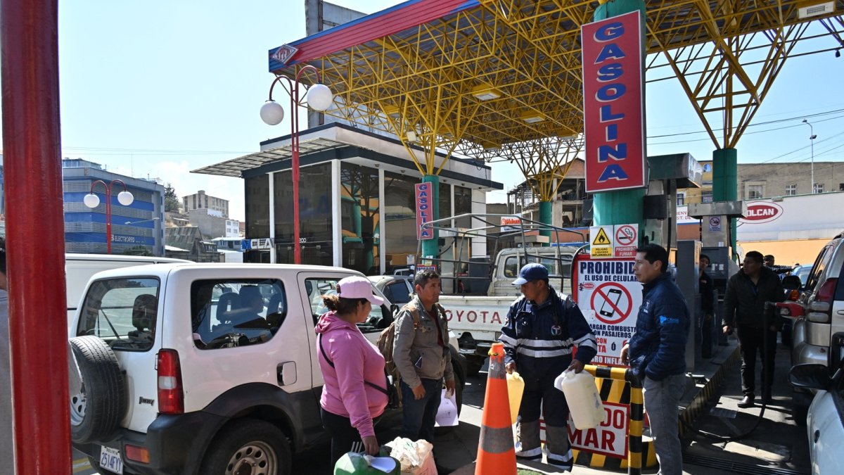 La gente espera con contenedores de plástico para comprar combustible durante un paro de transporte de 24 horas debido a la escasez de combustible en La Paz el 23 de octubre de 2024.