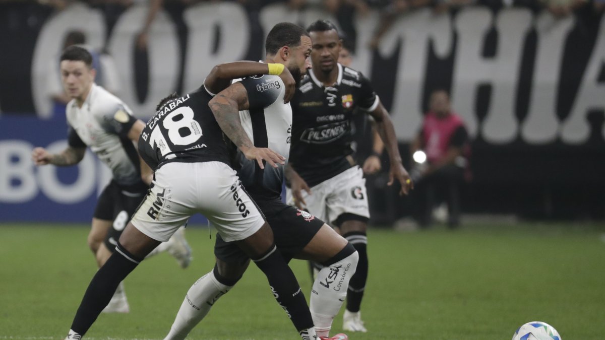 Memphis Depay (c) de Corinthians disputa el balón con Bryan Carabalí (i) de Barcelona.