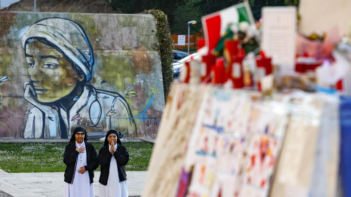 Monjas rezan cerca de la estatua de Juan Pablo II en la entrada del Hospital Gemelli, donde está hospitalizado el Papa Francisco, en Roma, Italia.