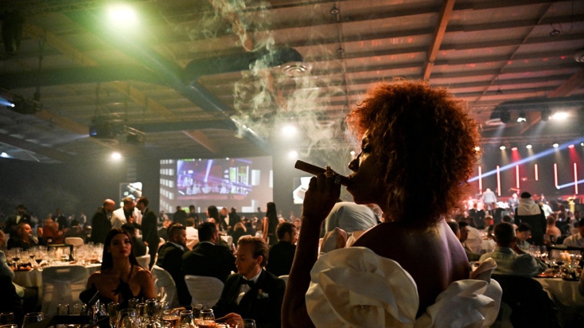 Una mujer fuma un puro durante una subasta de humidores realizada como parte de la clausura del XXV Festival del Habano en La Habana, el 28 de febrero de 2025