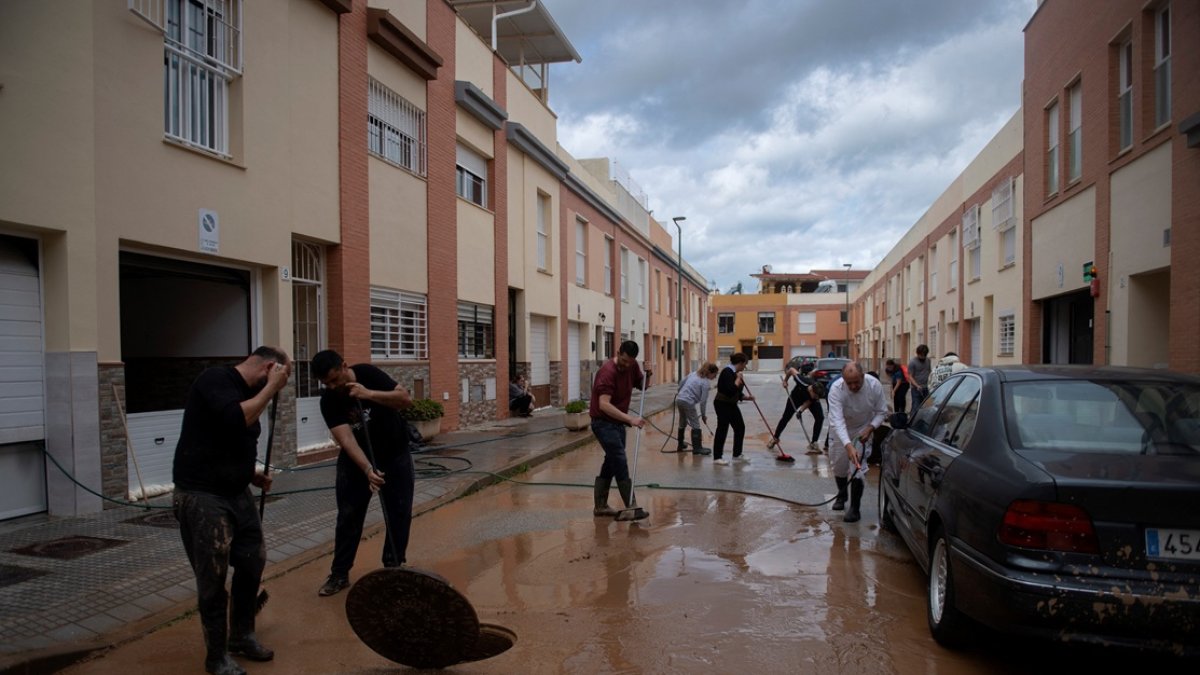 Los residentes limpian su calle inundada en Campanillas, cerca de Málaga, sur de España, el 18 de marzo de 2025.