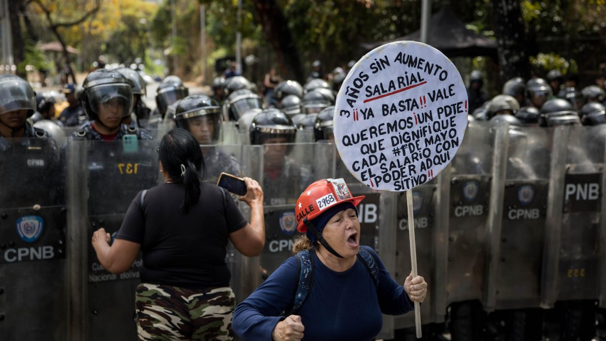 Personas se manifiestan durante una protesta frente a miembros de la Policía Nacional Bolivariana (PNB) que custodian los accesos a la Universidad Central de Venezuela, en Caracas (Venezuela).