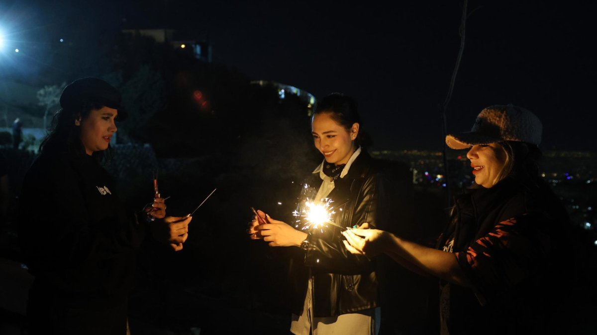 Niñas iraníes encienden petardos durante una fiesta tradicional del fuego llamada 'Charshanbeh Suri' en Teherán, Irán, el 18 de marzo de 2025.
