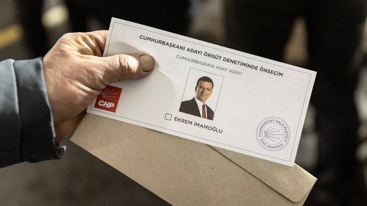 Una hombre muestra una papeleta con la efigie del alcalde de Estambul, Ekrem Imamoglu.