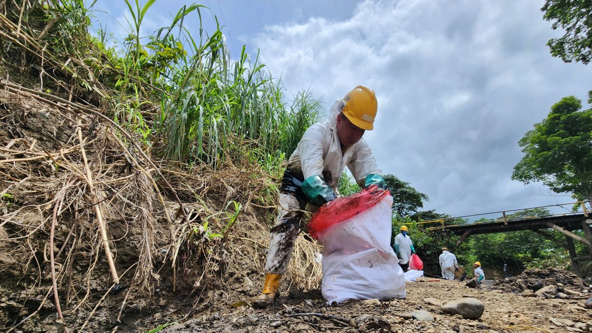 Limpieza. Un obrero de Petroecuador limpia la orilla del río Caple, contaminada por el derrame de crudo.